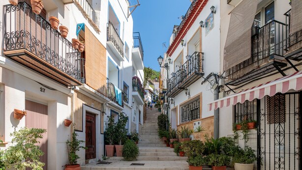 A narrow street with buildings on either side, potted plants, and a clear blue sky. - Apartment 'La Torre' with Wi-Fi and Air Conditioning (Alicante (Alacant))