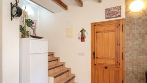 A kitchen with a white refrigerator, wooden stairs, a wooden door, and a wall clock. - Apartment 'La Torre' with Wi-Fi and Air Conditioning (Alicante (Alacant))