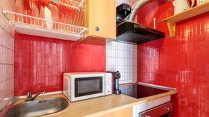 A kitchen with a microwave, sink, and wooden cabinets. - Apartment 'La Torre' with Wi-Fi and Air Conditioning (Alicante (Alacant))