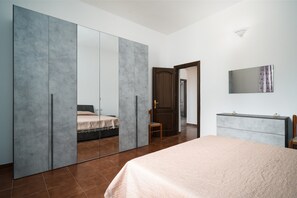 A bedroom with a bed, a wardrobe, a dresser, and a mirror. - Holiday Home 'Casa Picchereddu' with Private Terrace (Orosei)