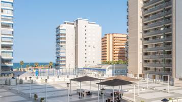Una piazza moderna in città, con edifici alti, posti a sedere all'aperto e cielo sereno.
