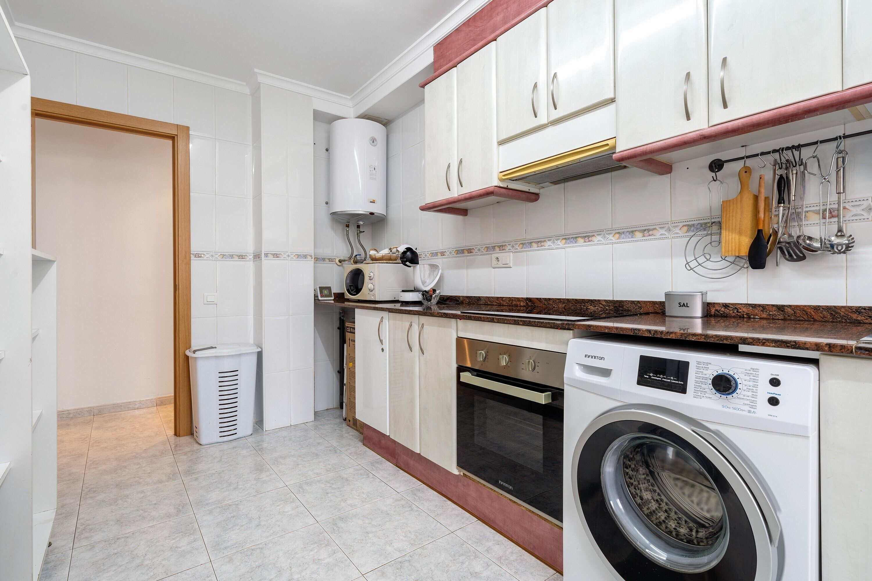 Una cocina equipada con lavadora, estufa y armarios.