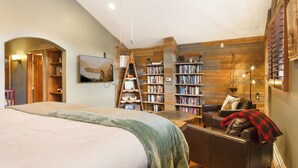 A bedroom with a large bed, a wooden bookshelf, a desk, and a chair. - Private Hot Tub & Pet Friendly + Beds For Any Group Dynamic (Avon)