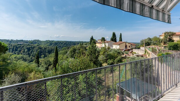 A balcony with a view of a lush landscape, including trees and buildings. - House of Flowers holiday home with balcony and Wi-Fi (Montopoli vald’arno)