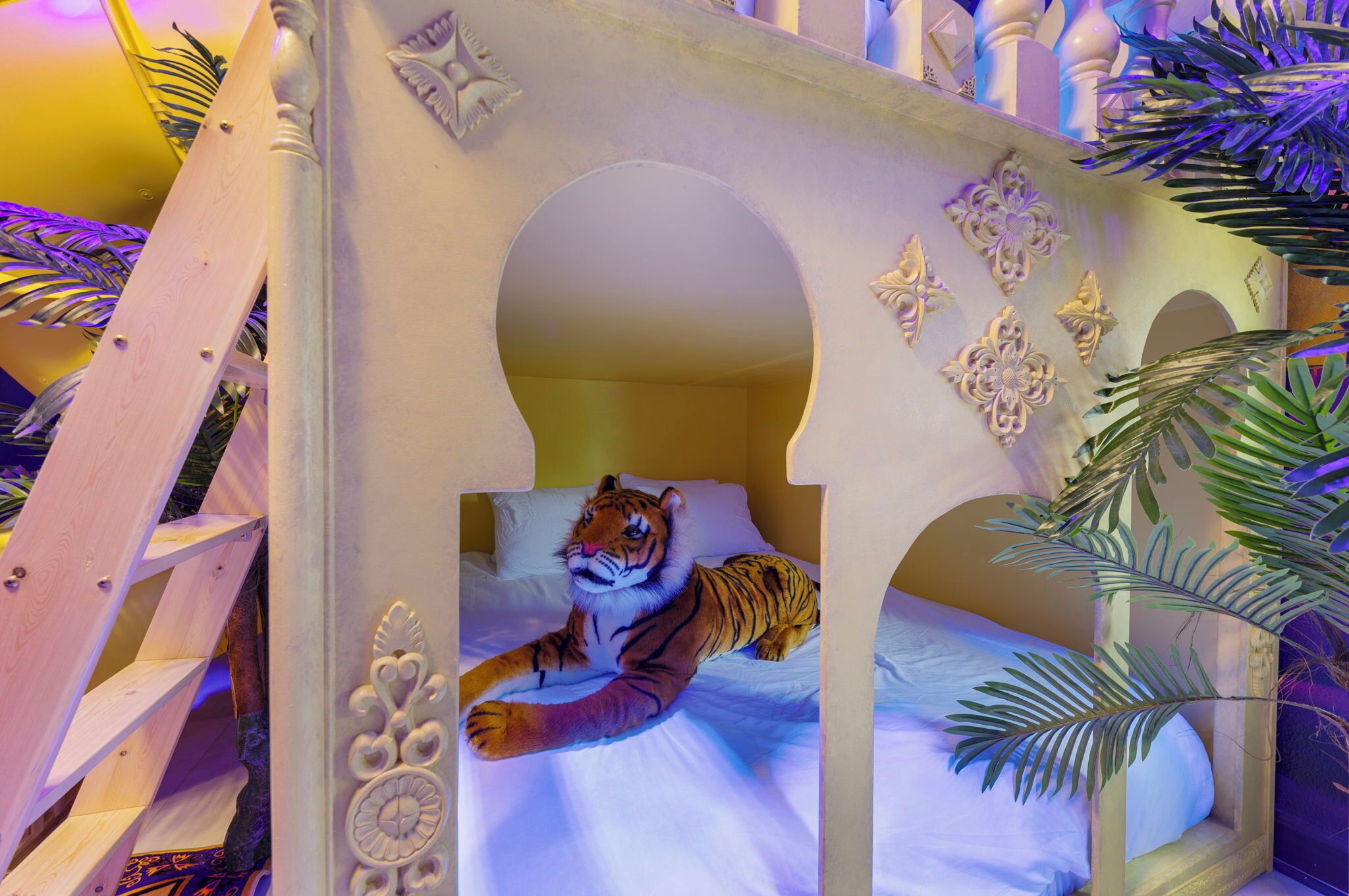Een tijger ligt op een bed met versierde witte balustrades en bloemdecoraties.