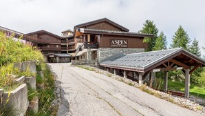 Un immeuble à plusieurs étages portant une enseigne indiquant « ASPEN RESIDENCE DE TOURISME ».