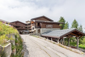 Un immeuble à plusieurs étages portant une enseigne indiquant « ASPEN RESIDENCE DE TOURISME ».