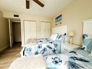 A bedroom with a bed, two nightstands, a lamp, and a painting on the wall.