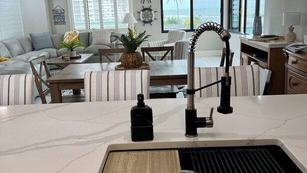 A modern kitchen with a marble countertop, a built-in sink, and a pendant light. - FOUND! Million Dollar View! Stunning Fort Meyers Beach Condo! Book Early & Save! (Fort Myers Beach)