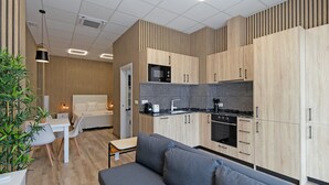 Eine moderne Küche mit Holzschränken, einer schwarzen Küchenrückwand und einem eingebauten Ofen.