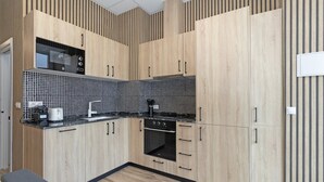 Eine moderne Küche mit Holzschränken, einer schwarz-weißen Küchenrückwand und einem eingebauten Backofen.