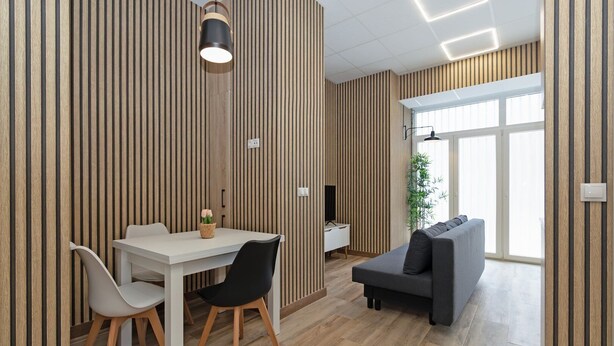 A modern interior with a dining area, sofa, and a large window. - GuestReady Essential- Blissful stay near the beach (Valencia)