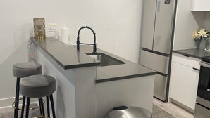 Eine moderne Küche mit Kochinsel, Edelstahlgeräten und minimalistischem Design.