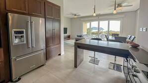 Een moderne keuken met roestvrijstalen apparatuur, houten keukenkastjes en een groot eiland.