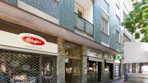 Un edificio con escaparate identificado como 'Flagship Store' y un restaurante llamado 'RESTAURANT TRAVEL AID'.
