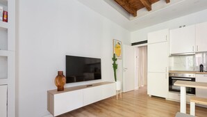 Una cocina moderna con armarios blancos, encimera de madera y horno empotrado.