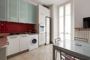 Una cocina moderna con lavadora, estufa y refrigerador.