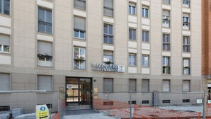 Un edificio de varios pisos con un cartel que dice 'MAZZOEMI ASSICURAZIONI' en la fachada.