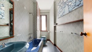 Un baño estrecho con una bañera, un lavabo e inodoro.