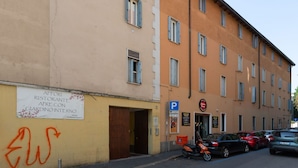 A multi-story building with a restaurant sign, a parking sign, and a motorcycle parked in front.
