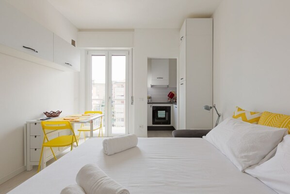 Un dormitorio con una cama, un escritorio y una silla.
