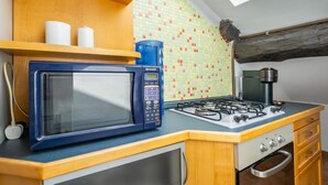 A compact kitchen with a microwave, gas stove, and a coffee maker on the countertop. - GuestHost - Bright APT Milan Garibaldi & Moscova! (Milano)