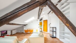 An attic room with a white sofa, a dining table with chairs, and a TV. - GuestHost - Bright APT Milan Garibaldi & Moscova! (Milano)