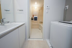 A modern bathroom with a white sink, mirror, and shower area. - LIVION V Hatagaya by Tranova (Tokyo)