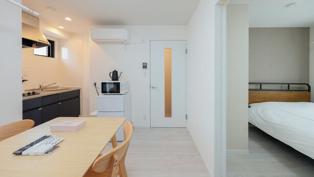 A compact hotel room with a kitchenette, a dining area, and a single bed. - LIVION V Hatagaya by Tranova (Tokyo)