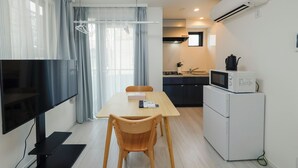 A compact living space with a dining area, kitchenette, and a TV. - LIVION V Hatagaya by Tranova (Tokyo)