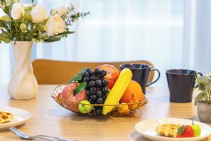 A dining table with a fruit basket, a vase with flowers, and a coffee mug. - LIVION V Hatagaya by Tranova (Tokyo)