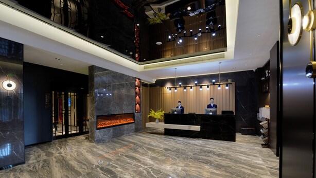 A modern lobby with a reception desk, a fireplace, and a high ceiling with recessed lighting. - Mei Hao Li Jinhui Square sto (Xi'an)