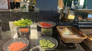 A buffet table with various food items including lettuce, tomatoes, cucumbers, and bread. - Mei Hao Li Jinhui Square sto (Xi'an)