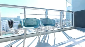 A balcony with two chairs and a floor lamp, overlooking a cityscape. - MODELLO Sangenjaya by Tranova (Tokyo)