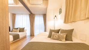 A hotel room with a large bed, a smaller bed, a desk, and a window with curtains. - MODELLO Sangenjaya by Tranova (Tokyo)