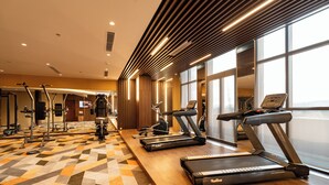 A gym with treadmills, weight machines, and a patterned floor. - Apec Mandala Mui Ne by Dolphin Hospitality (Mui Ne)