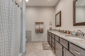 Un baño moderno con ducha, lavamanos y espejo.