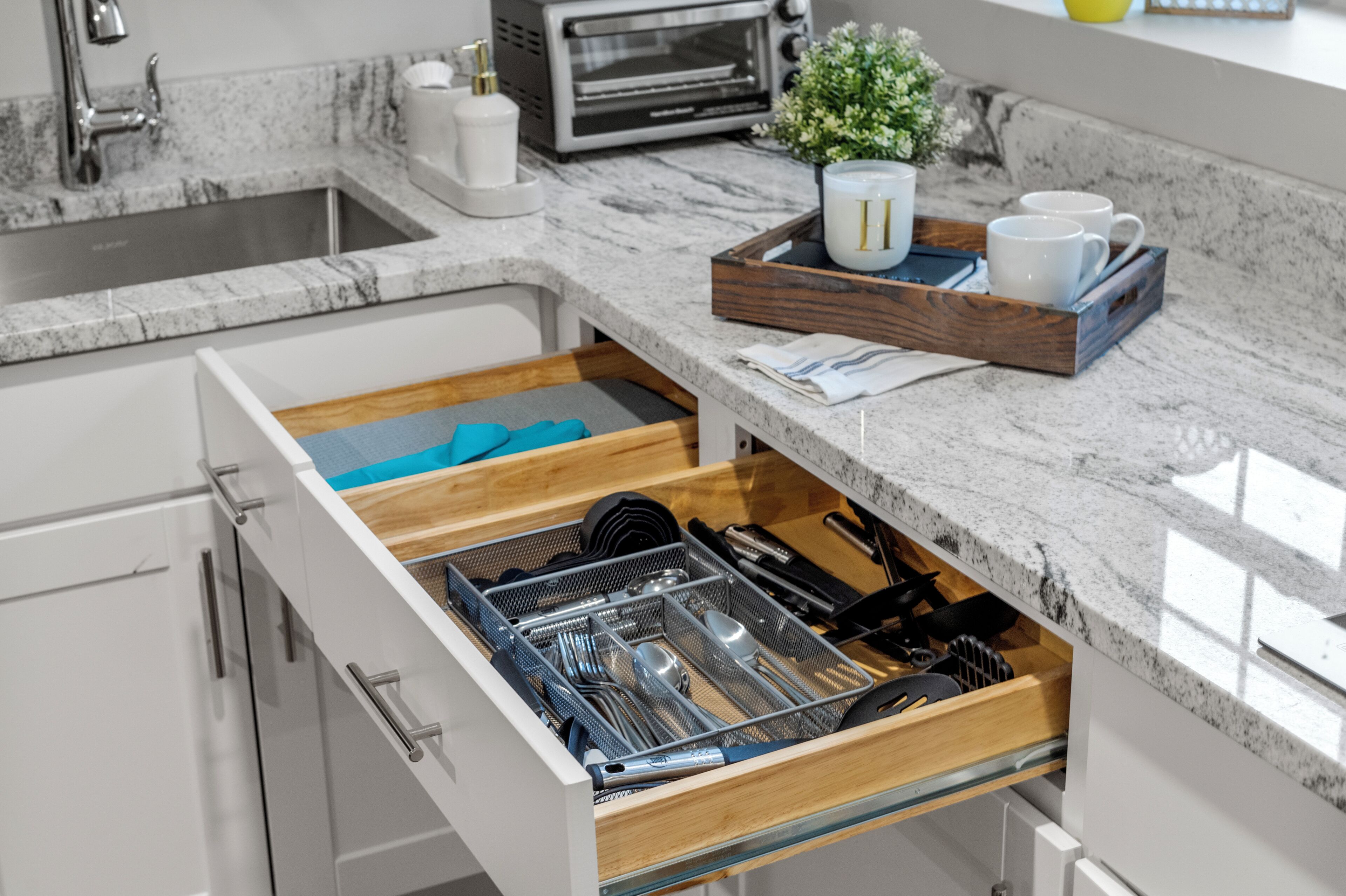 A kitchen with a built-in dishwasher, a microwave, and a small potted plant on the countertop.