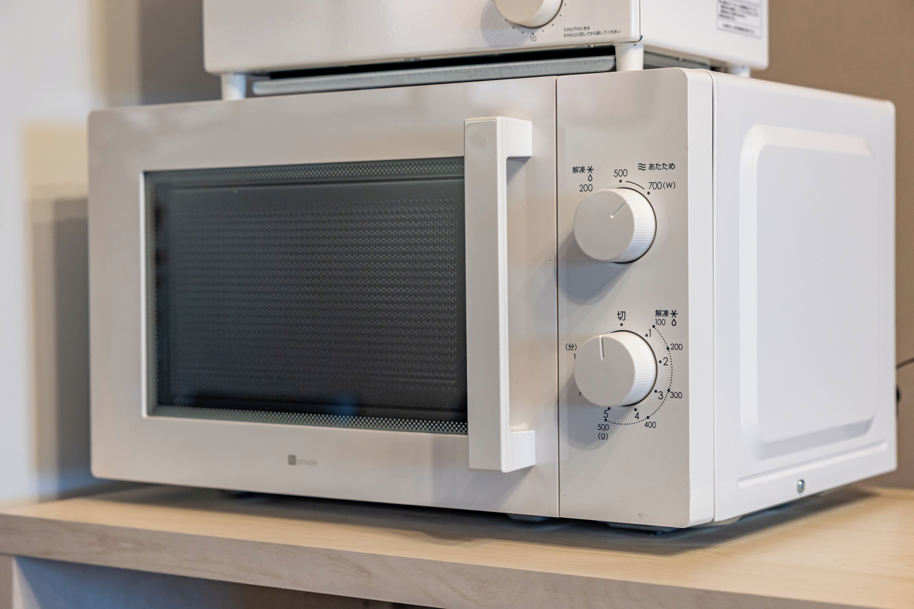 A white microwave oven with a digital display and two control knobs.