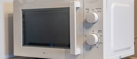 A white microwave oven with a digital display and two control knobs.