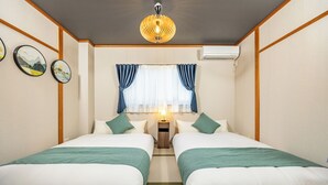 A hotel room with two beds, a nightstand, a lamp, a window with curtains, and wall art. - TACHIBANA Tengachaya (Osaka)