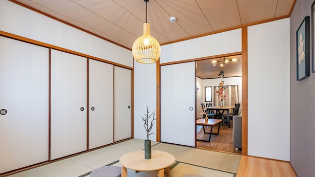 A traditional Japanese room with tatami flooring, a low wooden table, and a hanging light fixture. - TACHIBANA Tengachaya (Osaka)