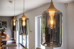 Pendant lights with exposed bulbs in a modern dining area. - Stunning 5 Bed in the Centre of Bourton (Cheltenham)