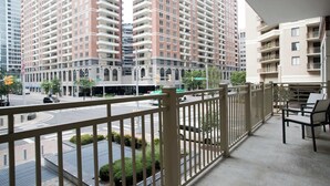 A high-rise residential building with multiple balconies and a street view.