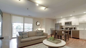 A modern apartment with a living room, kitchen, and dining area.