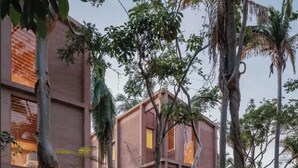A modern building with a symmetrical facade, surrounded by lush greenery and palm trees. - Rosa Morada: Luxury Villas with Private Beach (San Francisco)
