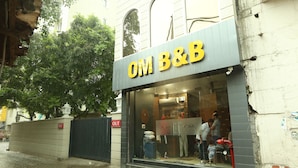 A storefront with a sign reading "OM B&B" and a closed gate with a red "OUT" sign. - Om B & B (Amritsar)