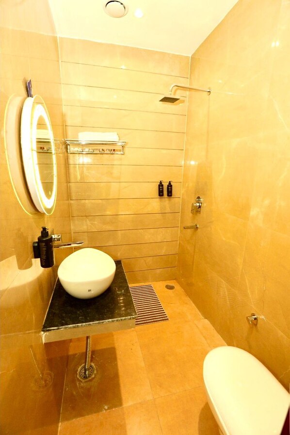 Un baño moderno con un lavabo blanco, un espejo, una ducha y un inodoro.