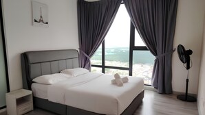 Een moderne slaapkamer met een groot bed, een nachtkastje, een ventilator en een raam met gordijnen.