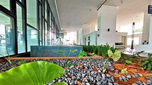 Een moderne binnenruimte met een zithoek, een waterpartij en diverse planten.